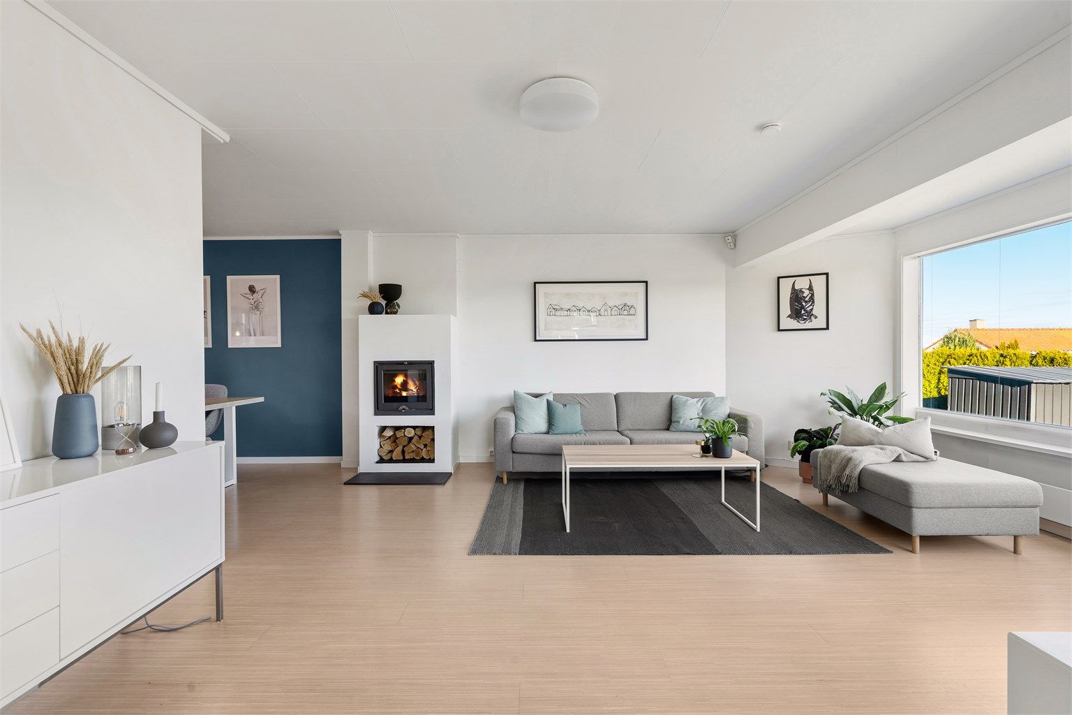 Delvis åpen løsning stue mot kjøkken. Flott peis som kan ses fra begge rom.