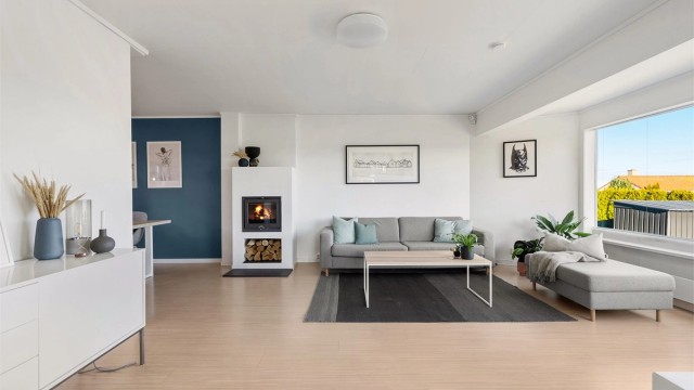 Delvis åpen løsning stue mot kjøkken. Flott peis som kan ses fra begge rom.