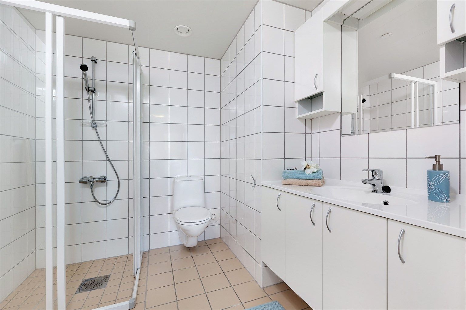 Delikat flislagt baderom med dusj, servant med skap, WC og opplegg for vaskemaskin og tørketrommel. Det er 2 bad i leiligheten.