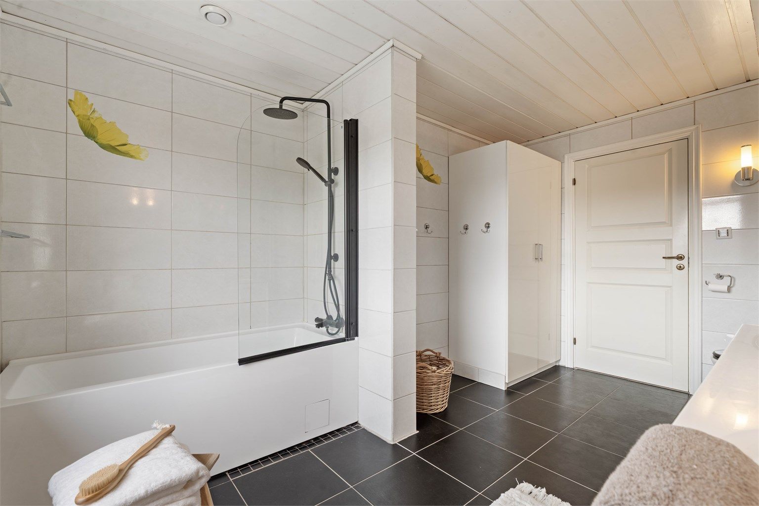 Badet er utstyrt med badekar med vegghengt armatur.
