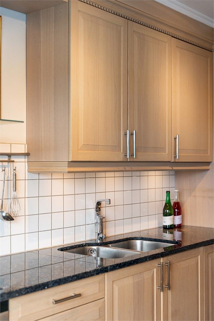 Detaljer som underlimt oppvaskkum og belysning under overskapene.
