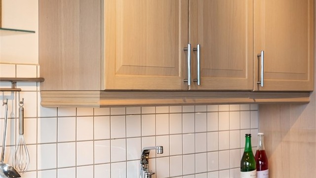Detaljer som underlimt oppvaskkum og belysning under overskapene.