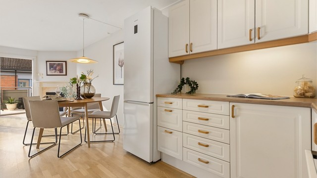 Kjøkkenet har profilerte fronter på skap og skuffer, og benkeplate med laminert overflate med nedfelt kjøkkenvask