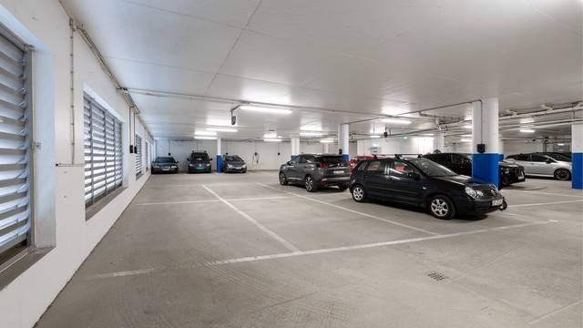 Fast biloppstillingsplass med elbillader i byggets lukkede garasjeanlegg.