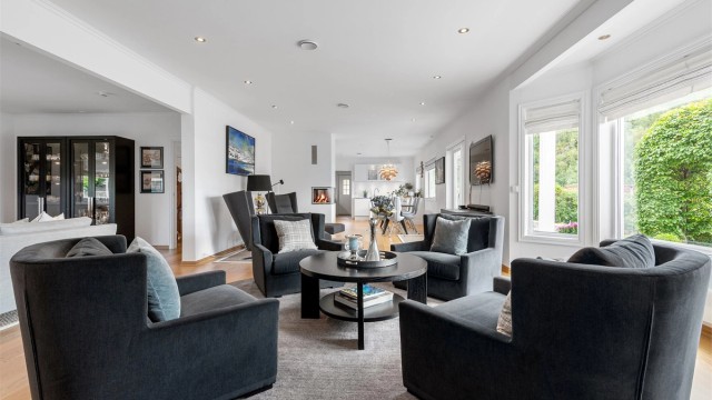 Stuen har direkte utgang til hagen og hagestuen Det er åpent mellom stue og kjøkken og avdelt med en hyggelig peis med glassdører