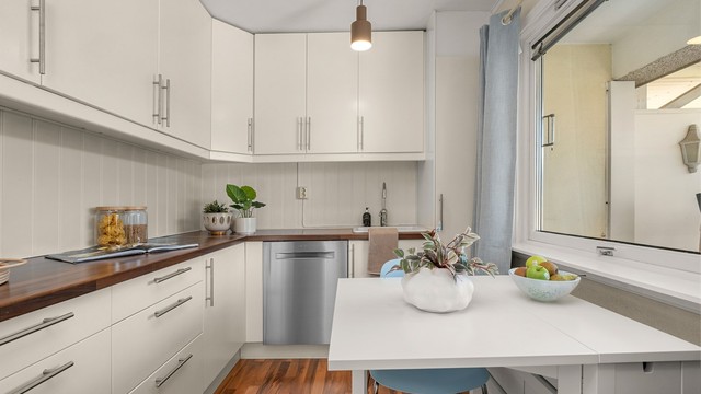 Kjøkkenet ligger naturlig tilbaketrukket fra stuen og er innredet med lyse slette flater og benkeplate av laminat.