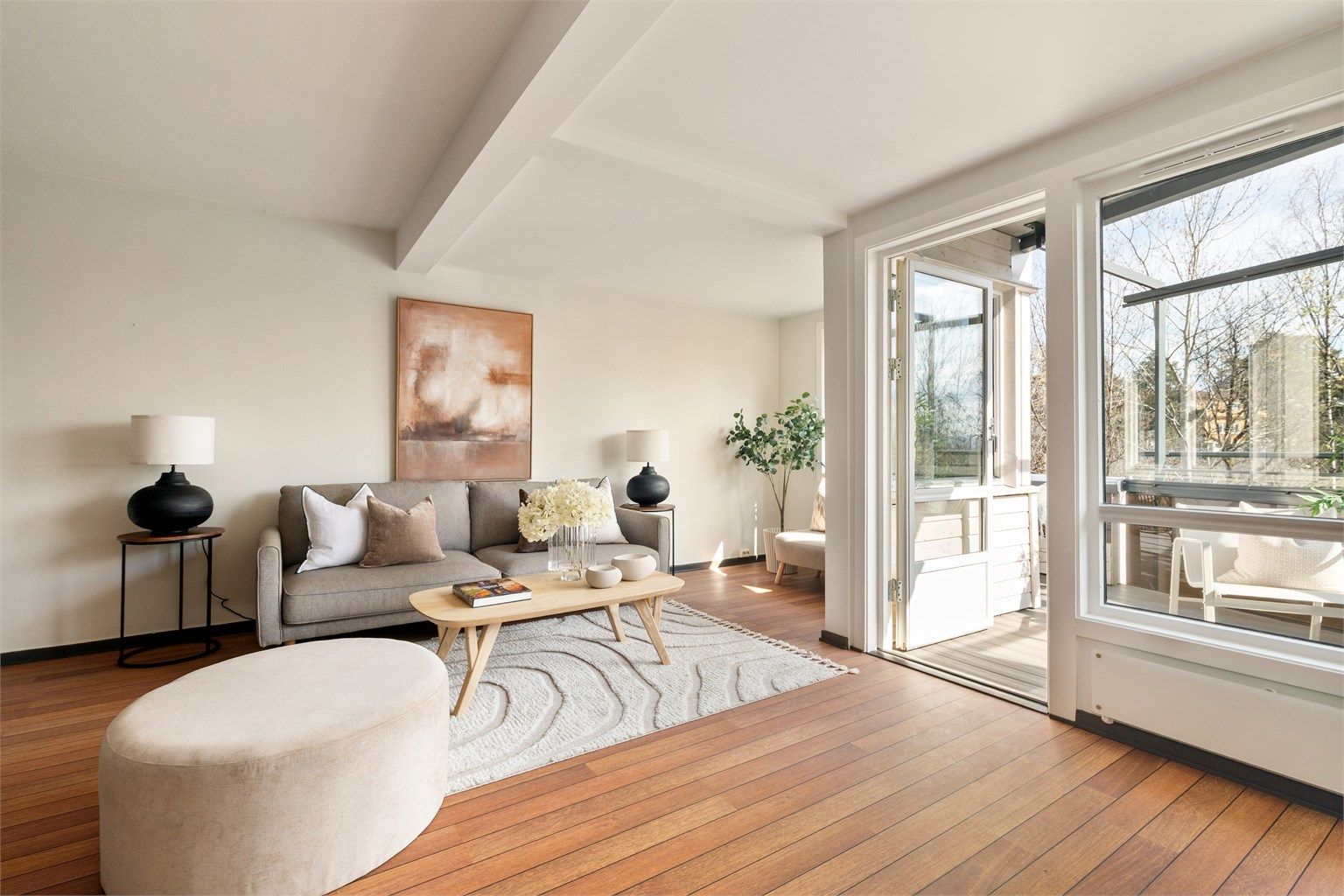 Stuen er svært romslig, med store vindusflater som gir mye naturlig lys inn i leiligheten.