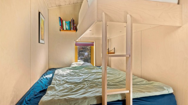 Plassbygde senger utnytter rommet og gjennomført materialbruk gir et ekslusivt preg.