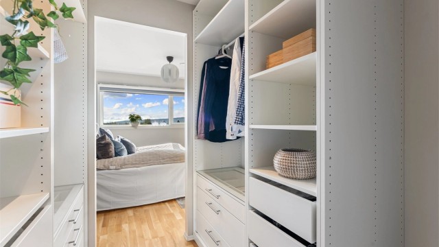 Walk-in-closet med praktisk innredning gir rikelig med oppbevaringsplass.
