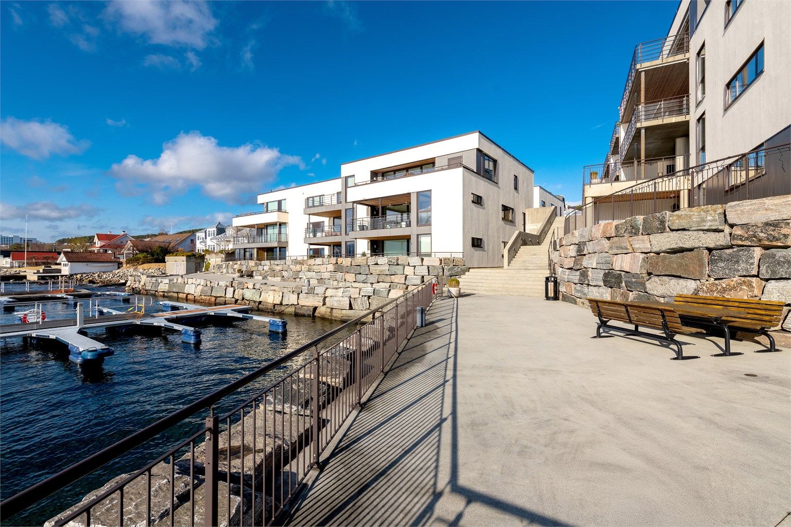 Fellesområder i strandkanten. Fellesområdene er pent opparbeidet med asfalterte gang- og trafikkarealer, plen og forstøtningsmurer. Opparbeidet lekeplass og det er småbåthavn ved sjøen