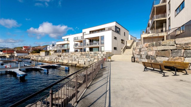 Fellesområder i strandkanten. Fellesområdene er pent opparbeidet med asfalterte gang- og trafikkarealer, plen og forstøtningsmurer. Opparbeidet lekeplass og det er småbåthavn ved sjøen