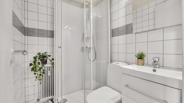 Badet ble oppgradert i 2020 med nytt dusjkabinett, nytt toalett, vegghengt servantinnredning med ovenpåliggende servant og speilskap med overlys.