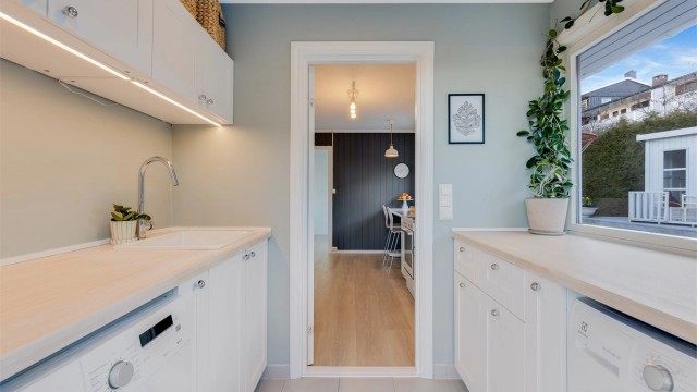 UTRYKKET I BOLIGEN er rent - og delikat. En kontrastvegg på kjøkkenet gir dybde.