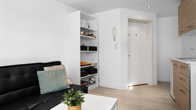 Åpen kjøkken- og stueløsning med sofaområde.
