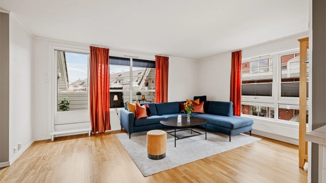 Stuen har gode lysforhold fra flere vindusflater, og gjennomgående parkett på gulvet.