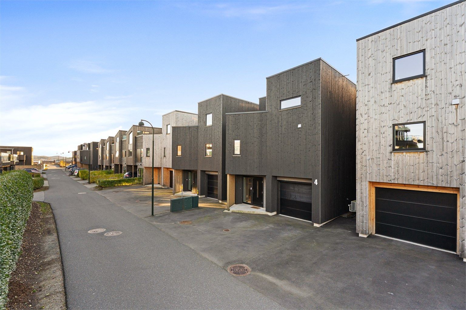 Uteområdet på fremsiden er asfaltert, og det er god plass til biler. Det er også El-bil lader i garasjen. 