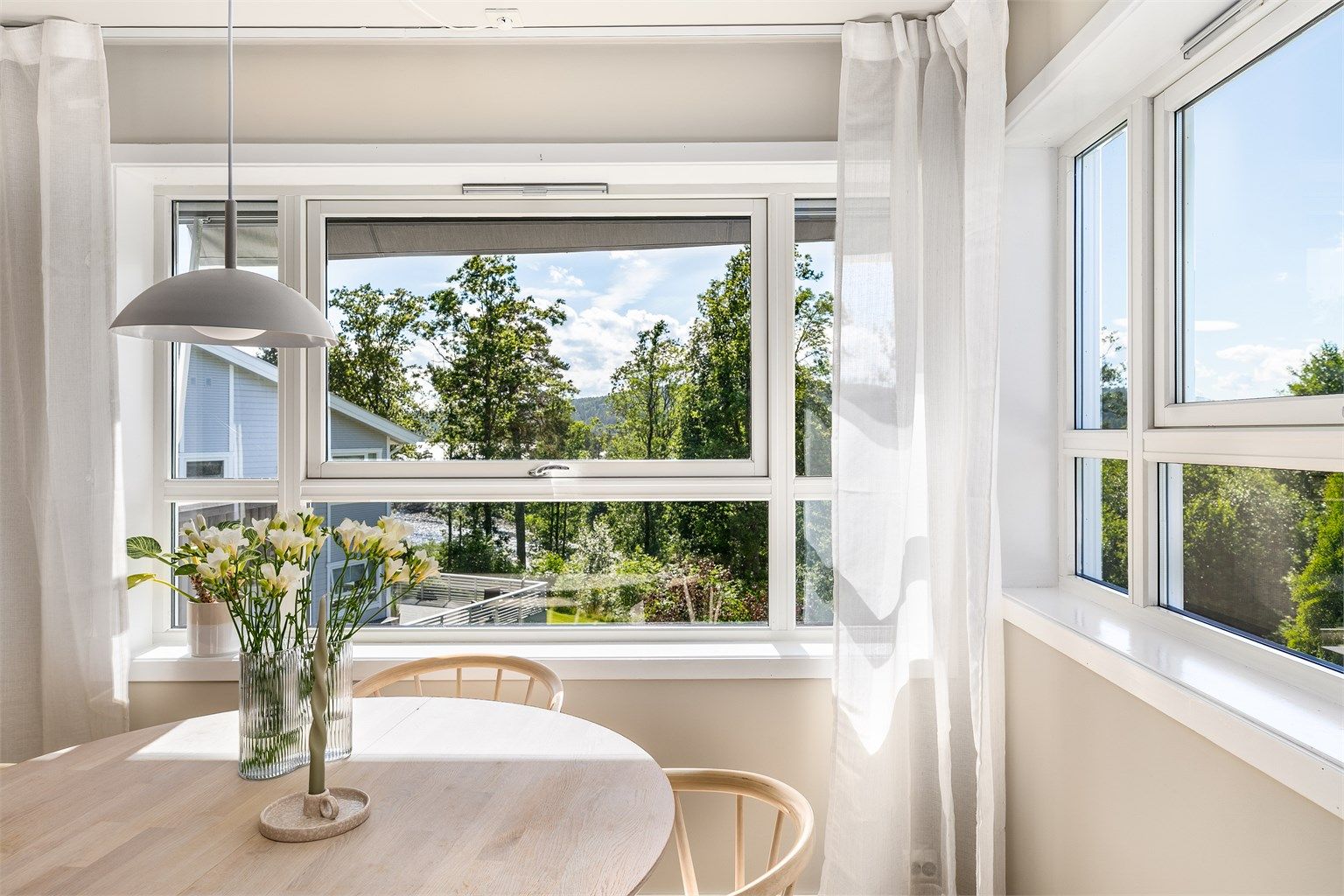 Spisebordet har sin naturlige plass i den lysfylte kroken foran kjøkkenet, hvor det er like fint utsyn som på balkongen.