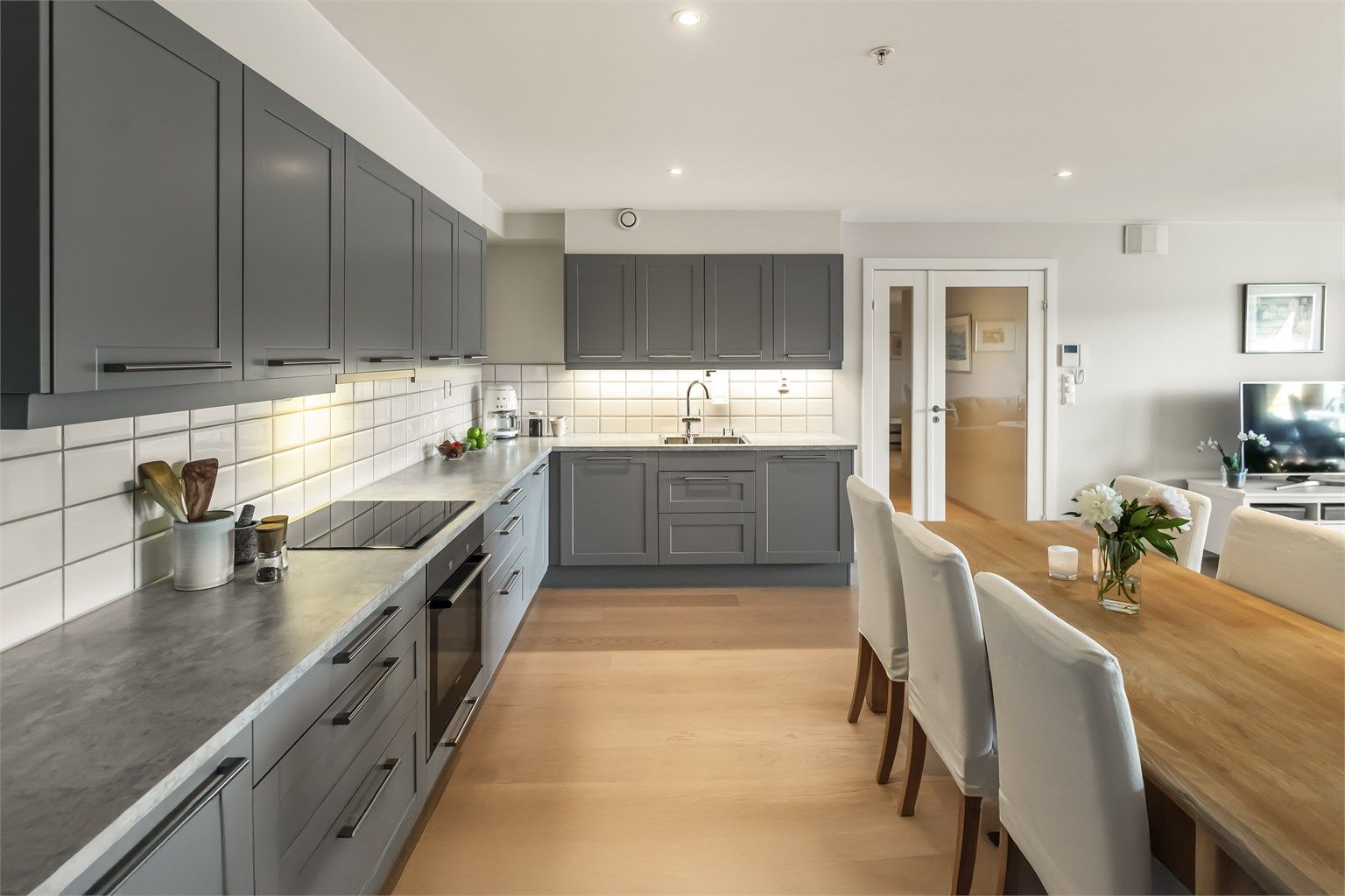 Kjøkkenet ligger i åpen løsning mot stuen, og det er montert et stilfullt Sigdal-kjøkken med profilerte fronter. Benkeplaten er i laminat. Kjøkkenet er godt utnyttet og har rikelig med skap- og benkeplass.