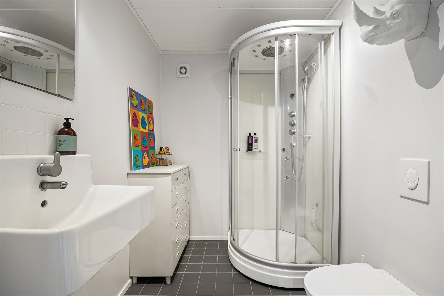 Badet i kjelleren er fra ca. 2013 og har flislagt gulv med gulvvarme, vegghengt toalett og dusjkabinett.