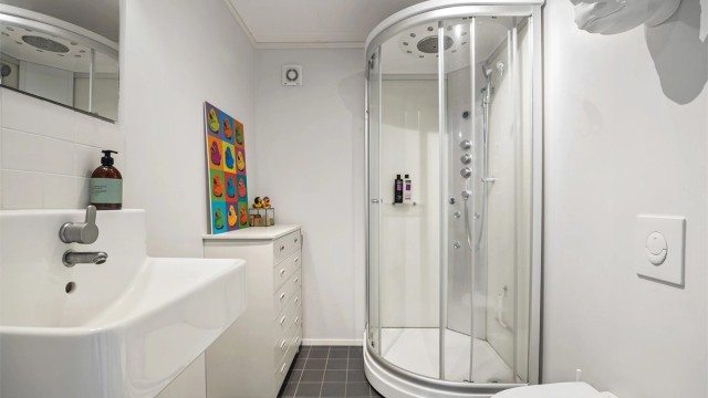 Badet i kjelleren er fra ca. 2013 og har flislagt gulv med gulvvarme, vegghengt toalett og dusjkabinett.