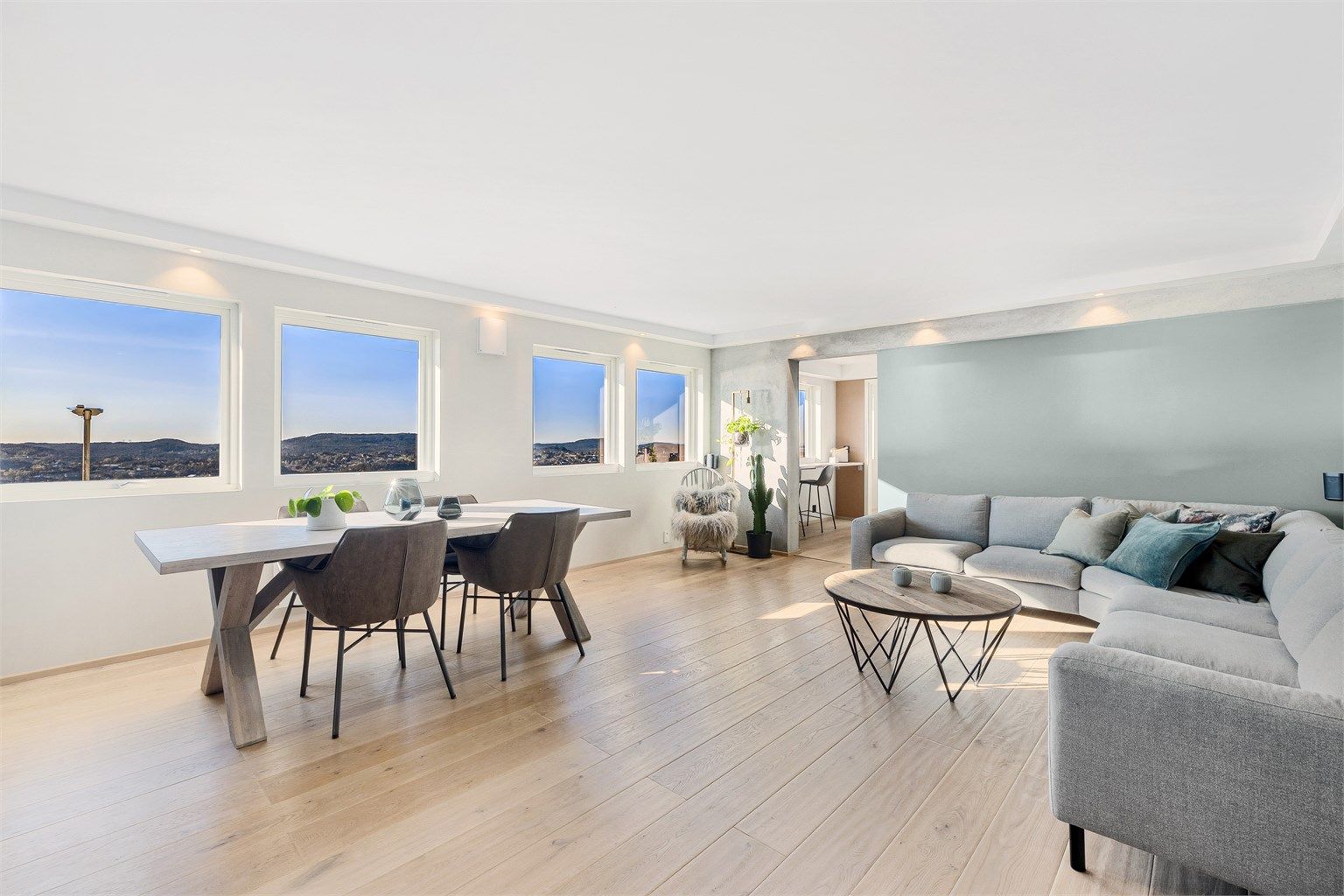 Innbydende stue med lyse overflater og et lekkert en-stavs hvitoljet tregulv.