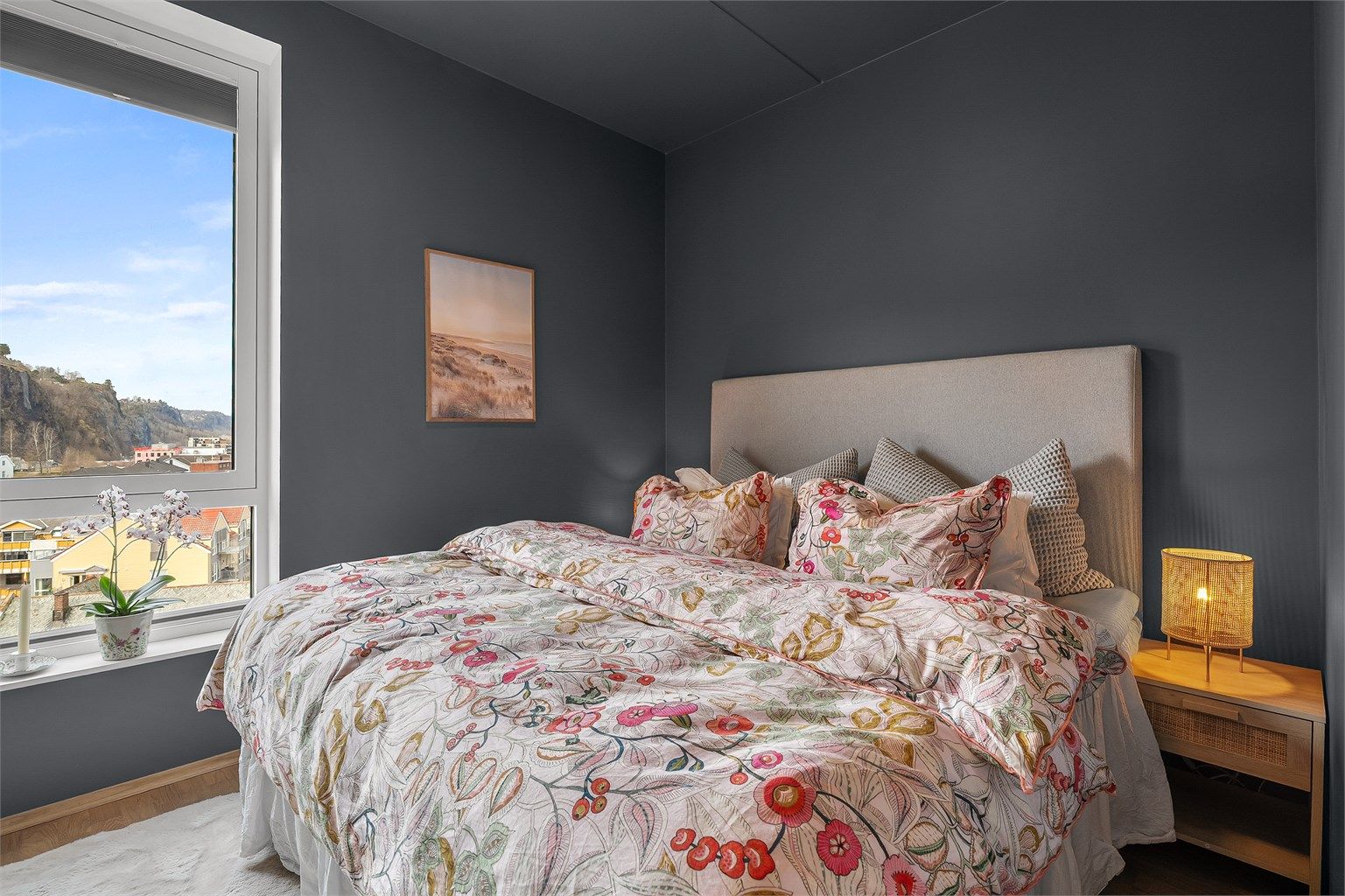 Hovedsoverommet har parkett på gulv, malte flater og utsikt mot sjøen.