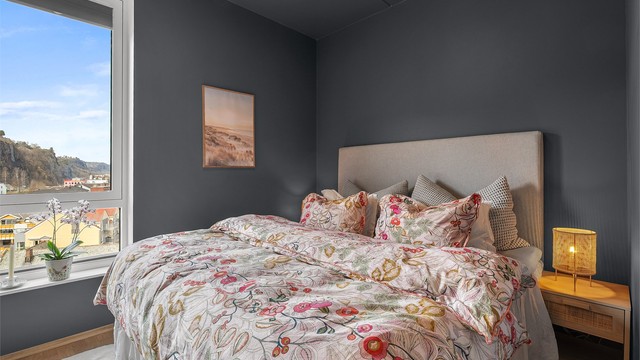 Hovedsoverommet har parkett på gulv, malte flater og utsikt mot sjøen.