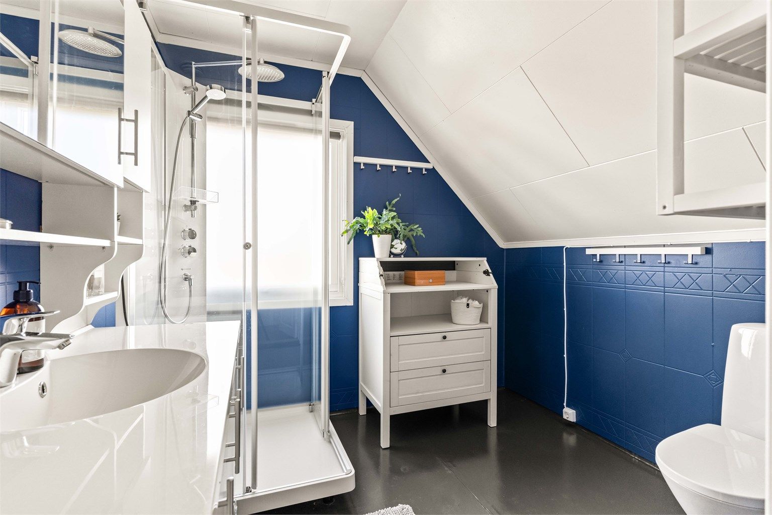 Badet i loftsetasjen har gulvvarme, dusjkabinett og servantinnredning.