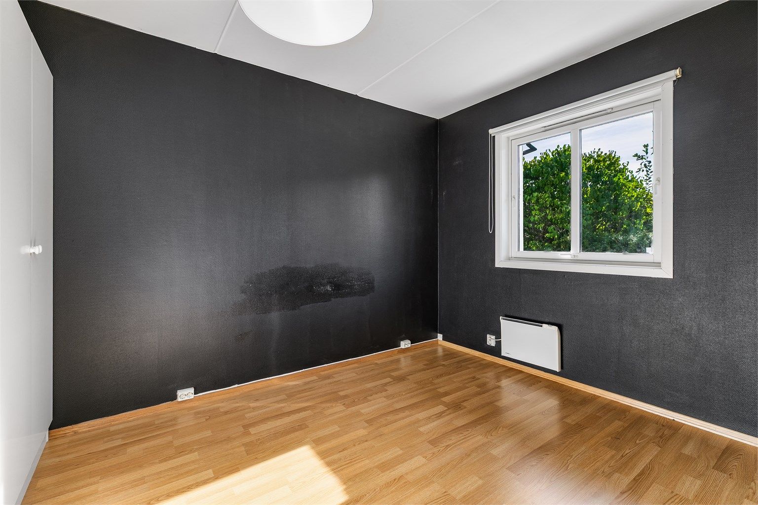 Utenfor soverommet er kun leilighetens balkong og den skjermede bakhagen.