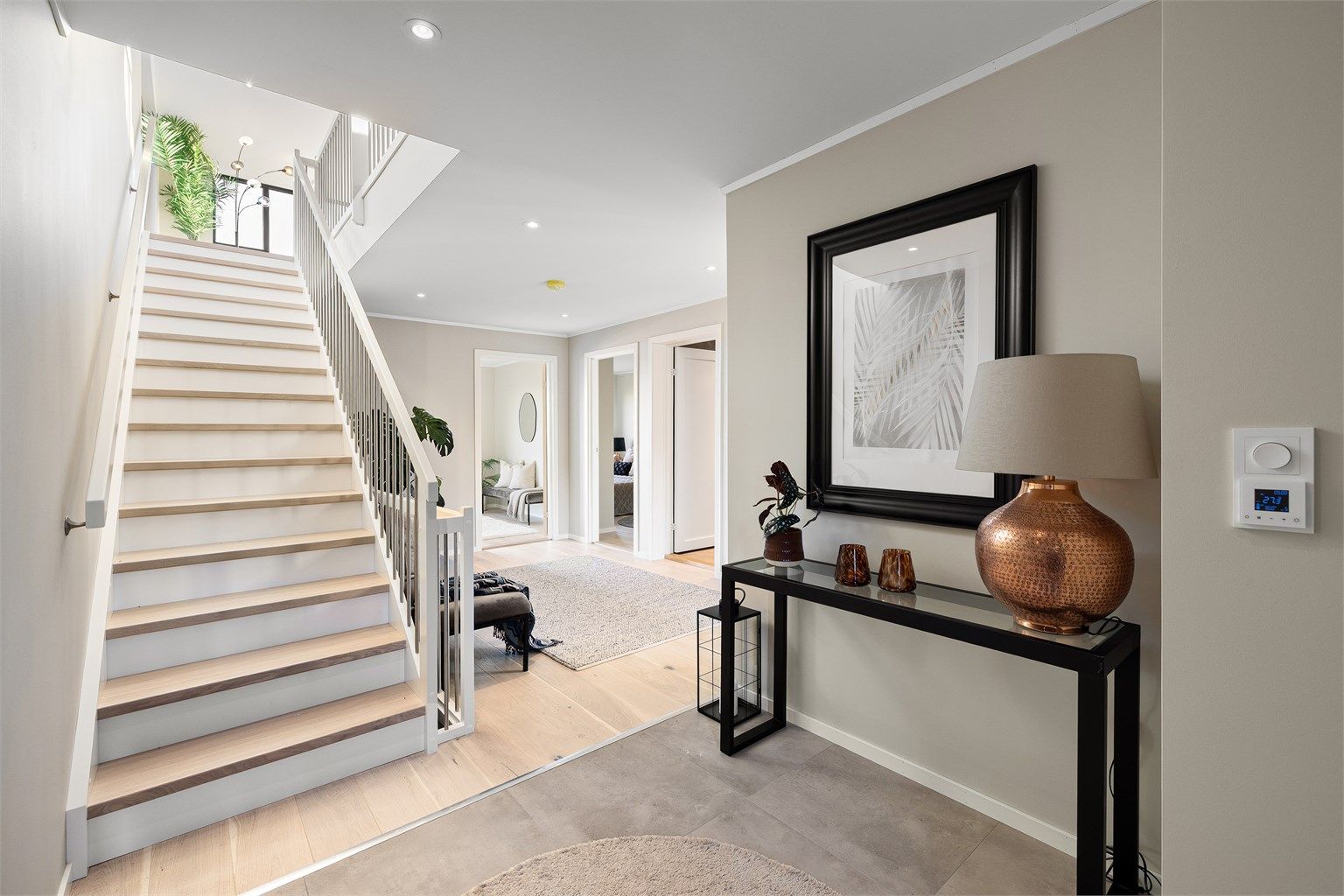 Lys og åpen entré med trappeforbindelse til boligens øvrige etasjer.