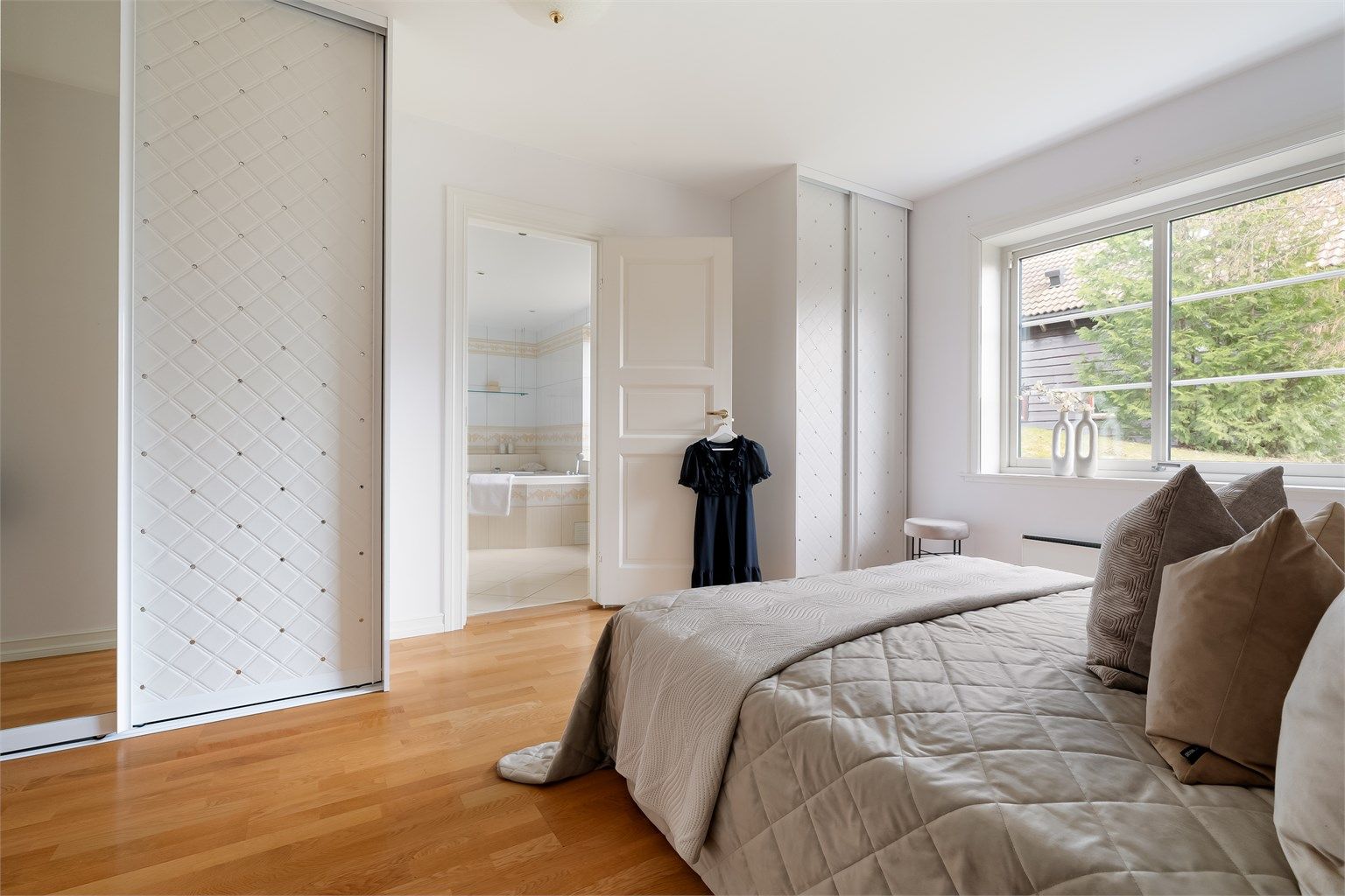 Store vindusflater i kombinasjon med takhøyden gir rommet en lys og luftig atmosfære.