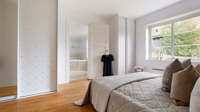 Store vindusflater i kombinasjon med takhøyden gir rommet en lys og luftig atmosfære.