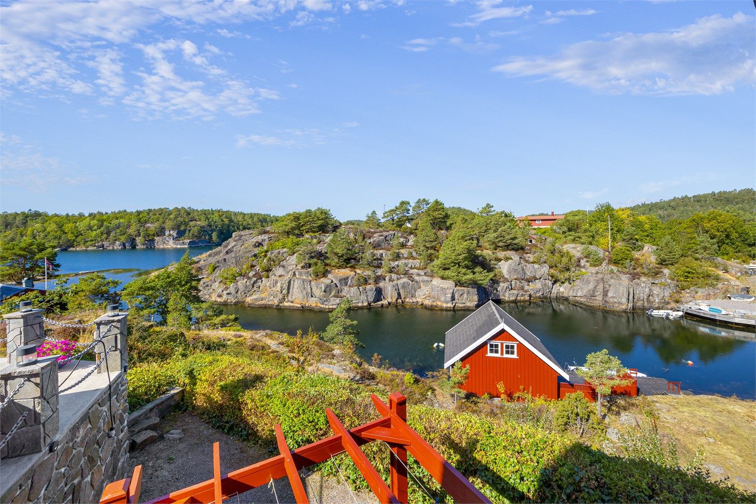 Utsikt fra eiendommen ned mot båthuset og det lune sundet.