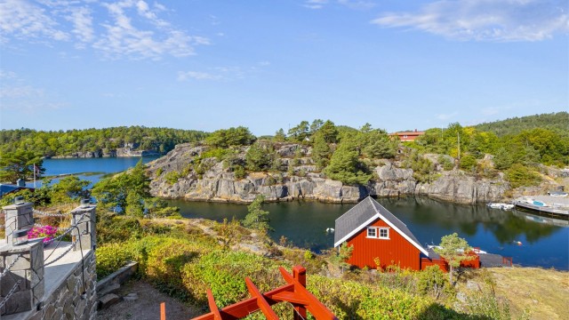 Utsikt fra eiendommen ned mot båthuset og det lune sundet.