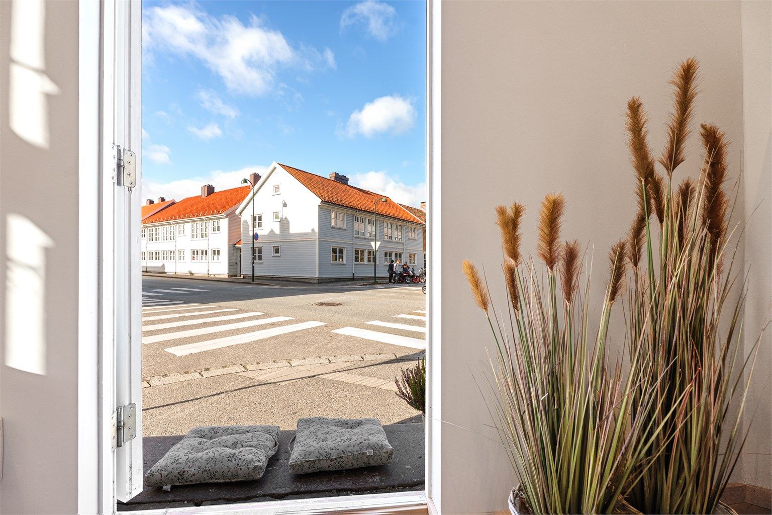 Store vindusflater og dør slipper inn rikelig med dagslys og understreker leilighetens luftige preg.
