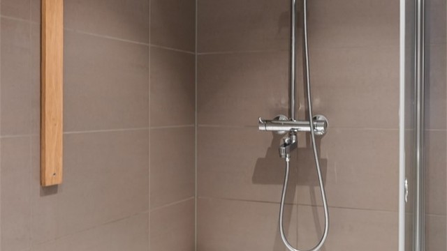 Regnfallsdusj og hånddusj. Badekaret kan enkelt fjernes og erstattes med de originale foldbare dusjdørene før overtagelse hvis ønskelig
