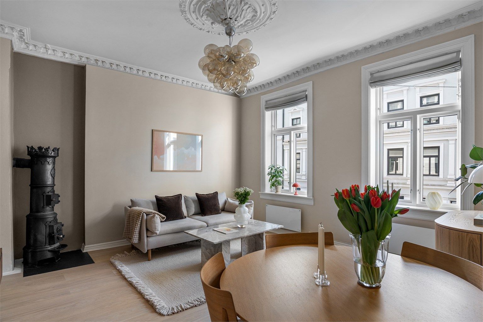 De store, klassiske vinduene slipper inn rikelig med lys i rommet, og det er god plass til både sofagruppe med tilhørende møblement og spisegruppe. 