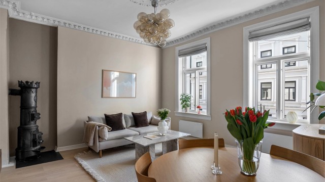 De store, klassiske vinduene slipper inn rikelig med lys i rommet, og det er god plass til både sofagruppe med tilhørende møblement og spisegruppe.