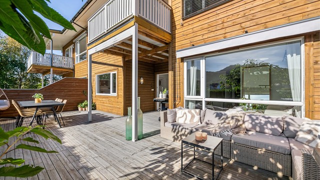 Store vindusflater skaper en sømløs overgang mellom stuen og uteområdet.