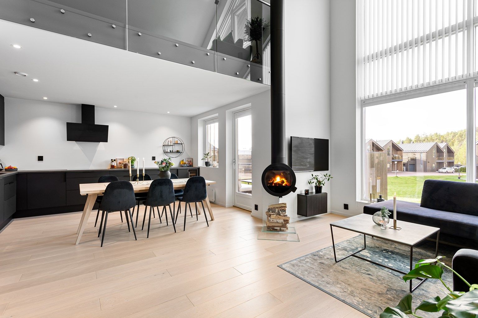 Stor bolig med åpen løsning mellom kjøkken og stue. Lekkert sotet glass i rekkverk på "galleri" ved tv-stuen