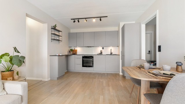 Kjøkkeninnredningen fra 2024 har glatte fronter og en slitesterk benkeplate i laminat.