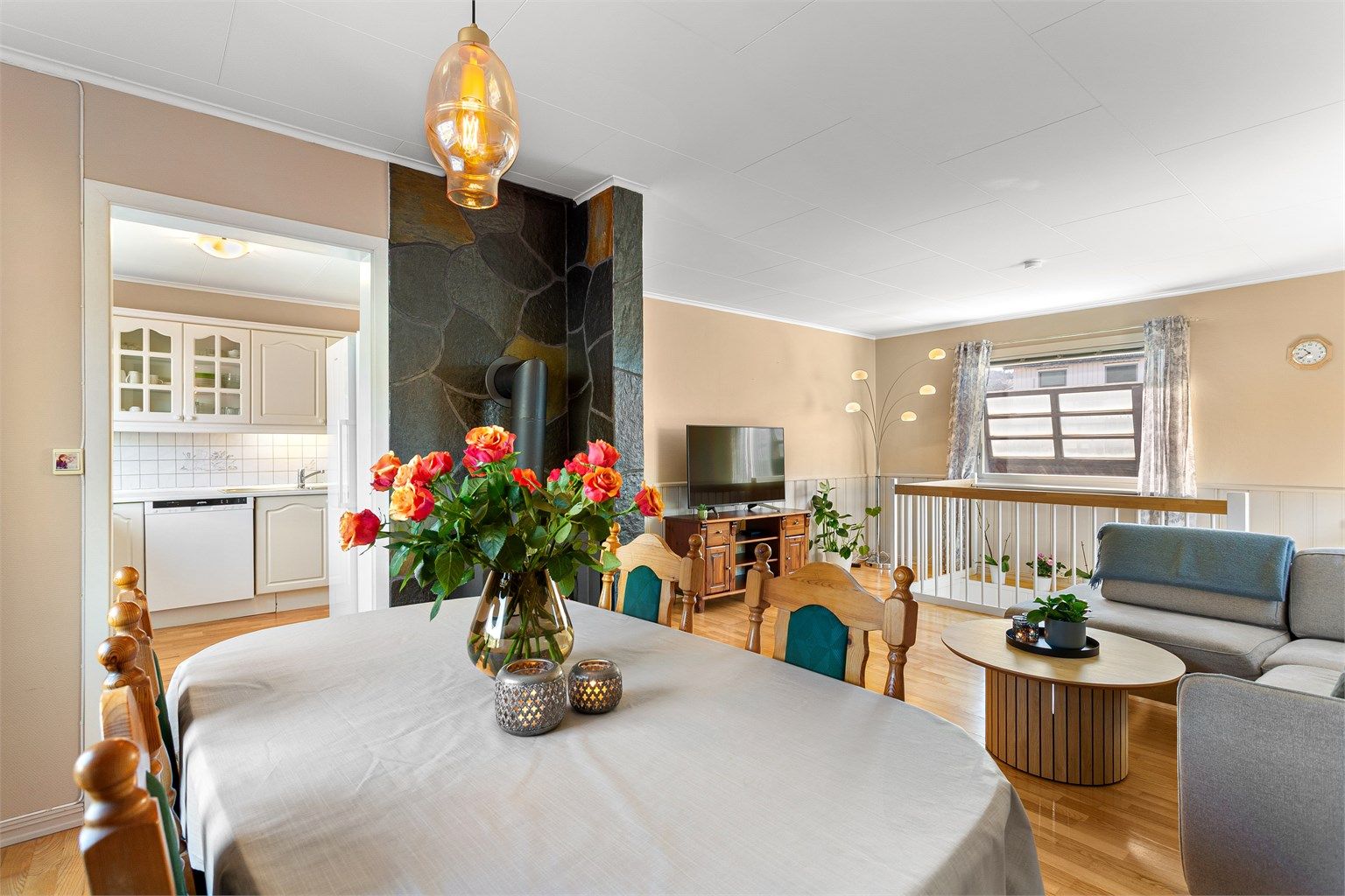 Stuen i første etasje har en åpen løsning mot spisestuen, med en sentralt plassert peisovn.