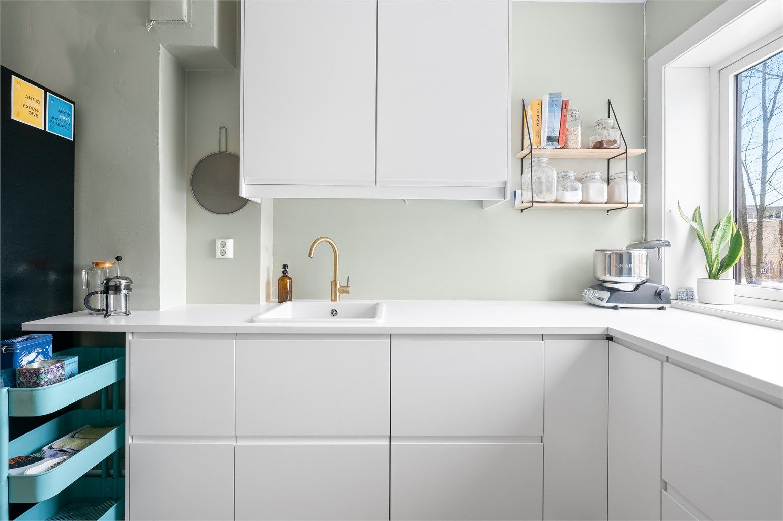 Videre består innredningen av glatte skapdører og lys benkeplate av laminat.