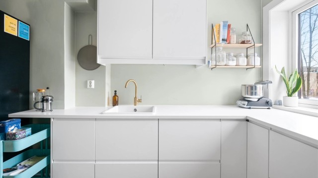 Videre består innredningen av glatte skapdører og lys benkeplate av laminat.