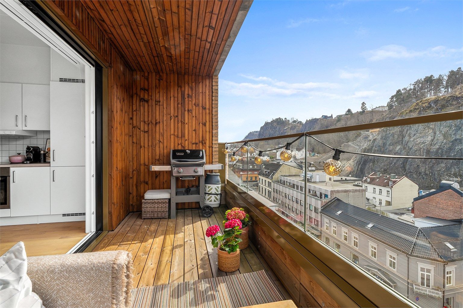 Terrassen har terrassebord i tre og rekkverk i glass som sikrer utsikten uten å skape innsyn.