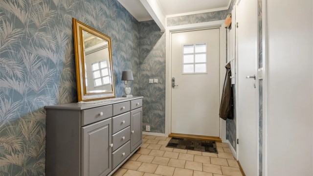 Velkommen inn. Entréen har praktiske fliser på gulvet og god plass til oppbevaring.