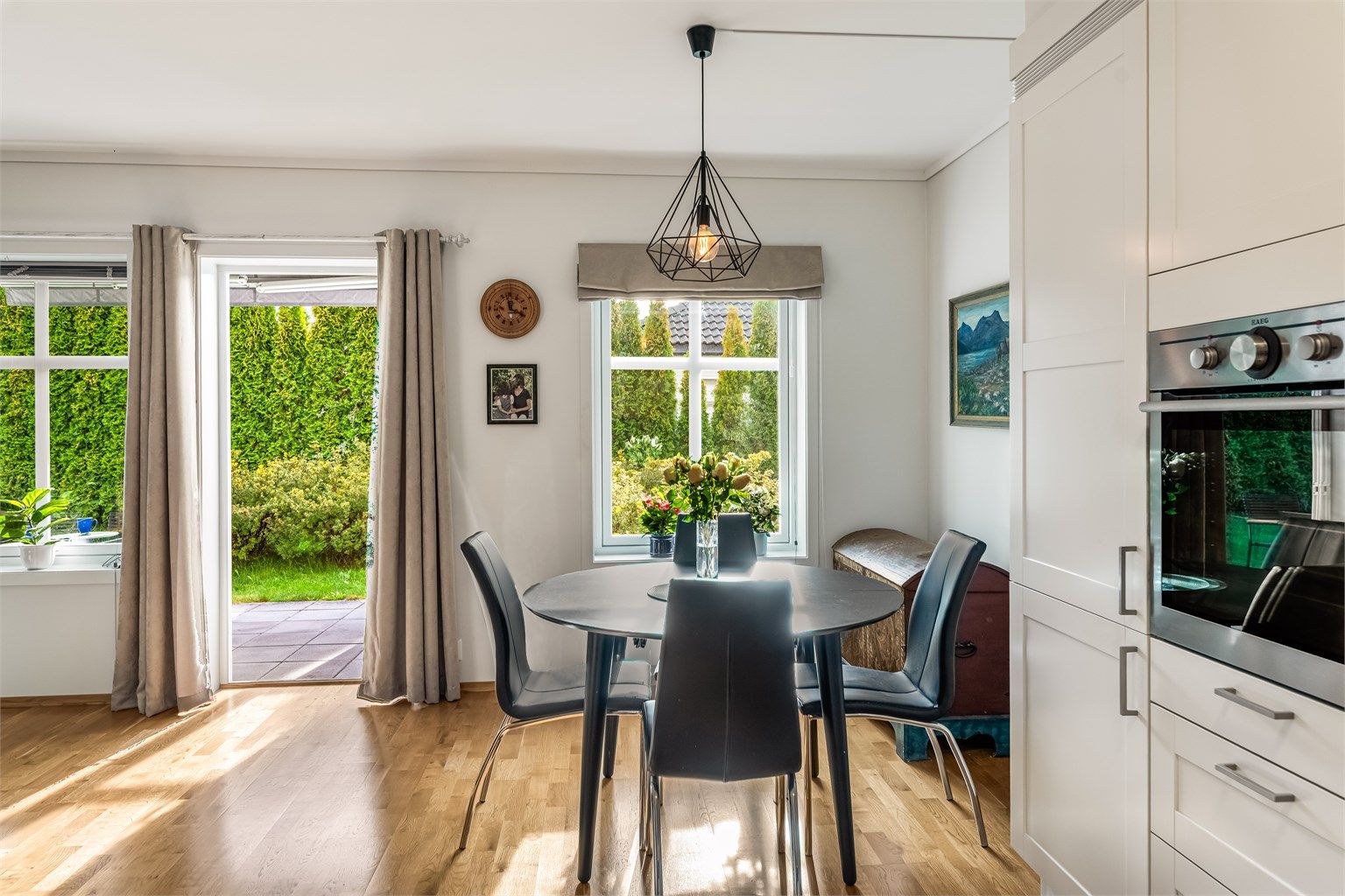 Spiseplassen ligger lyst til ved vinduet, med utsyn til hagen og direkte utgang til terrassen.