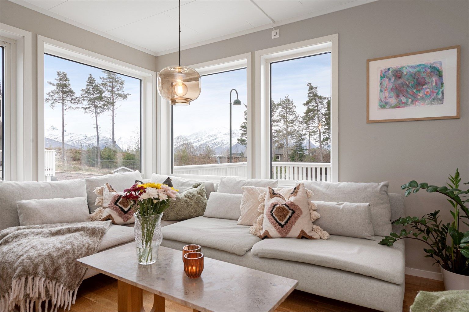 Stuen har parkett på gulv. De store vinduene gir rikelig med dagslys og en flott utsikt mot Sunnmørsalpane