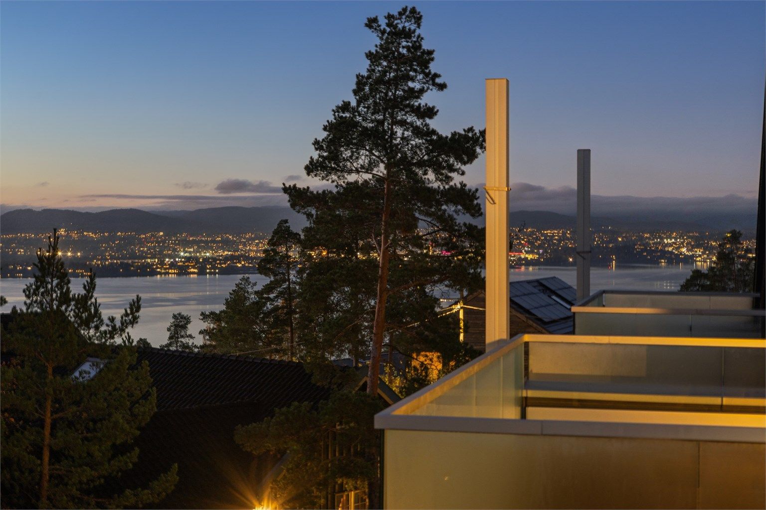 Fra takterrassen får du et vakkert utsyn over Oslofjorden, med kveldssolen som farger åsene i varme, stemningsfulle nyanser – en nydelig ramme for rolige kvelder og gode øyeblikk. Foto: Per Oscar Skjellnan v/Efkt
