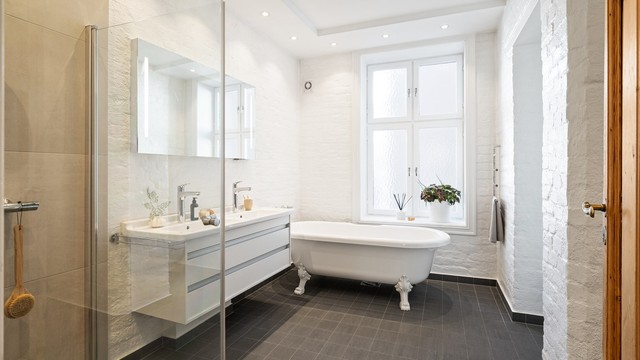 Badet er innredet med vegghengt servantinnredning, heldekkende dobbel servant, speil med integrert belysning, vegghengt toalett og opplegg for vaskemaskin.